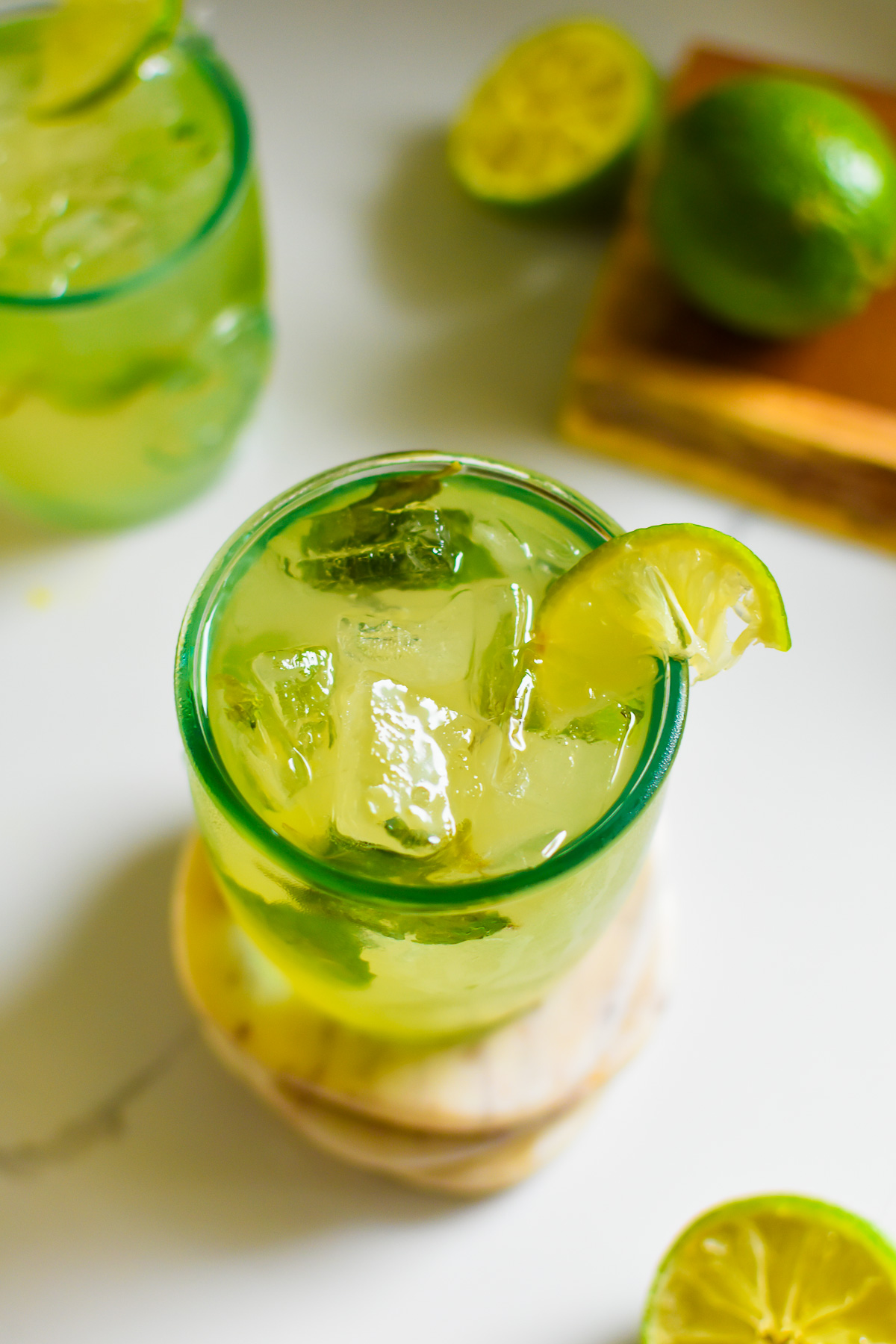 The best easy coconut water mocktail on the rocks with refreshing mint, lime, and ginger flavor notes in a recycled glass garnished with lime.