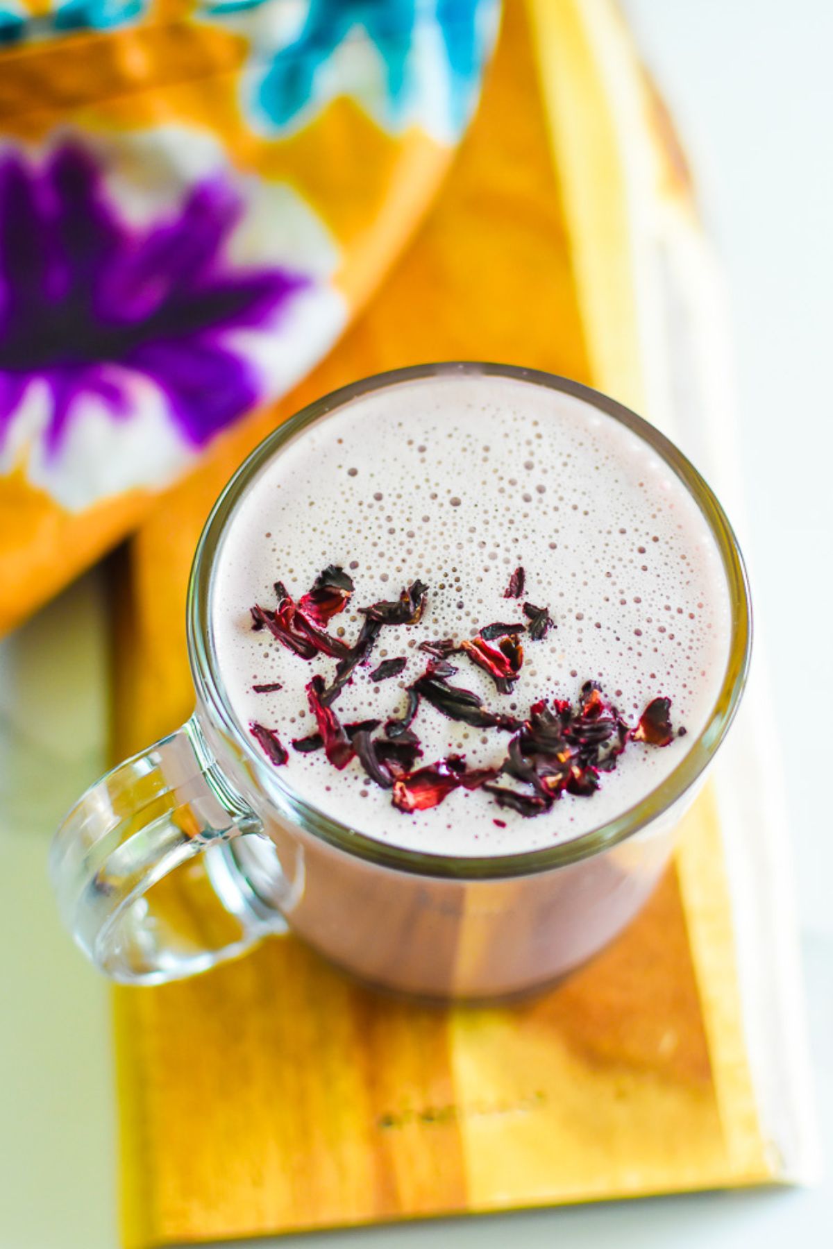 easy DIY hibiscus latte made with frothy warm coconut milk served in a clear glass.