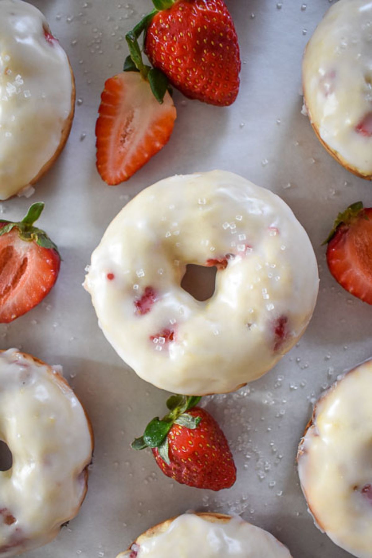 the best champagne spiked Valentine's donuts  surrounded by fresh strawberries and sprinkled with sugar crystals.