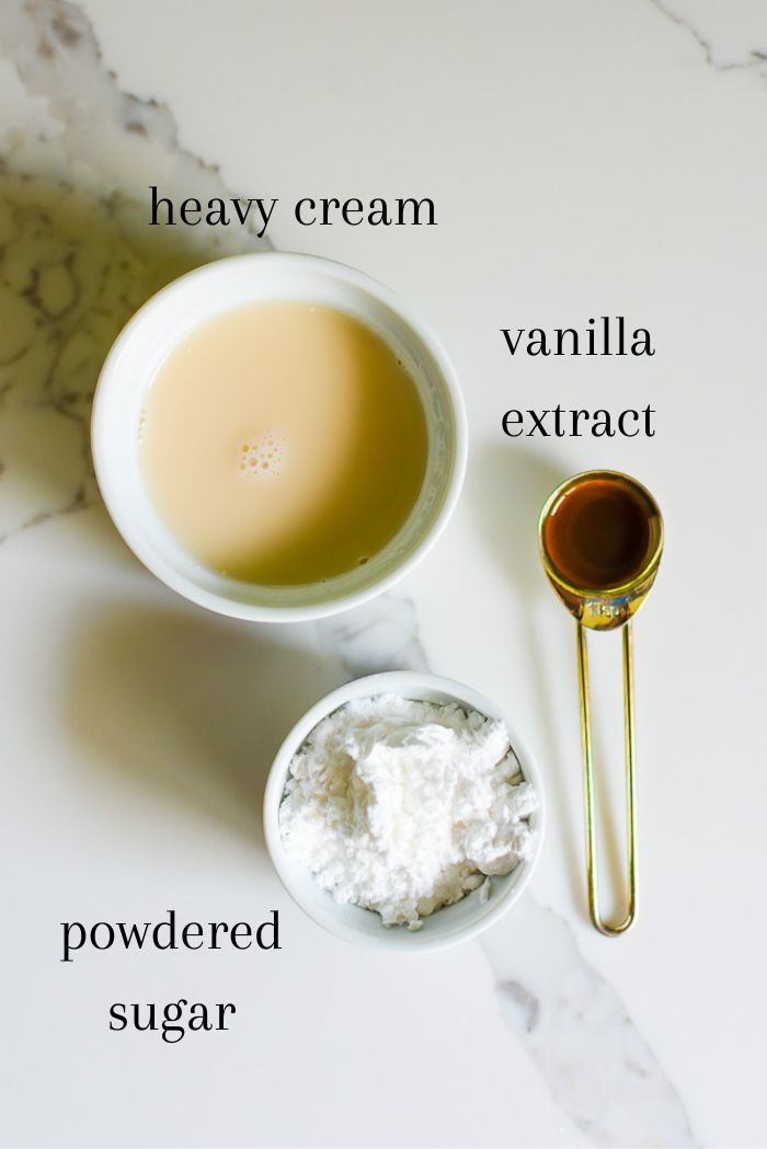 ingredients to make whipped cream from scratch on granite countertop: heavy cream, powdered sugar, and vanilla extract.