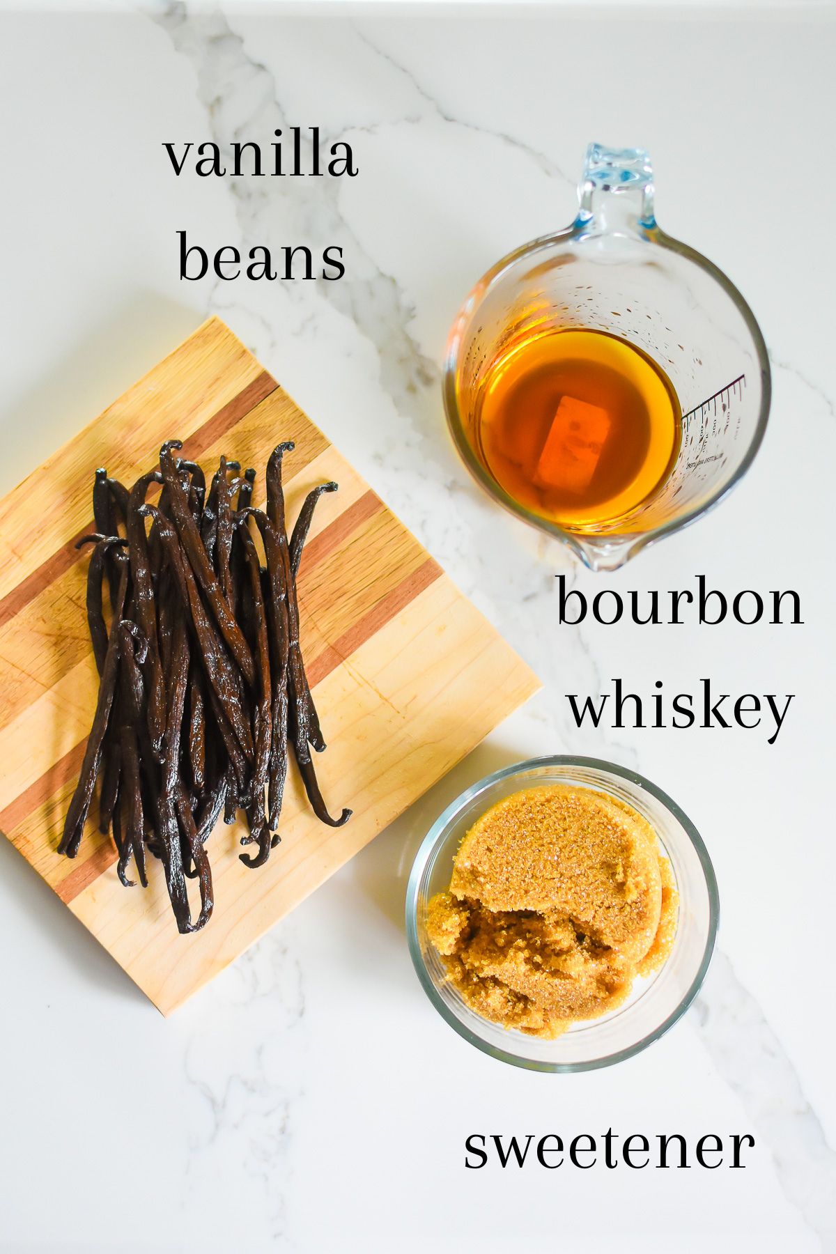 ingredients for making a small batch of the best homemade vanilla bean paste: pure organic vanilla beans, bourbon whiskey, and brown sugar.