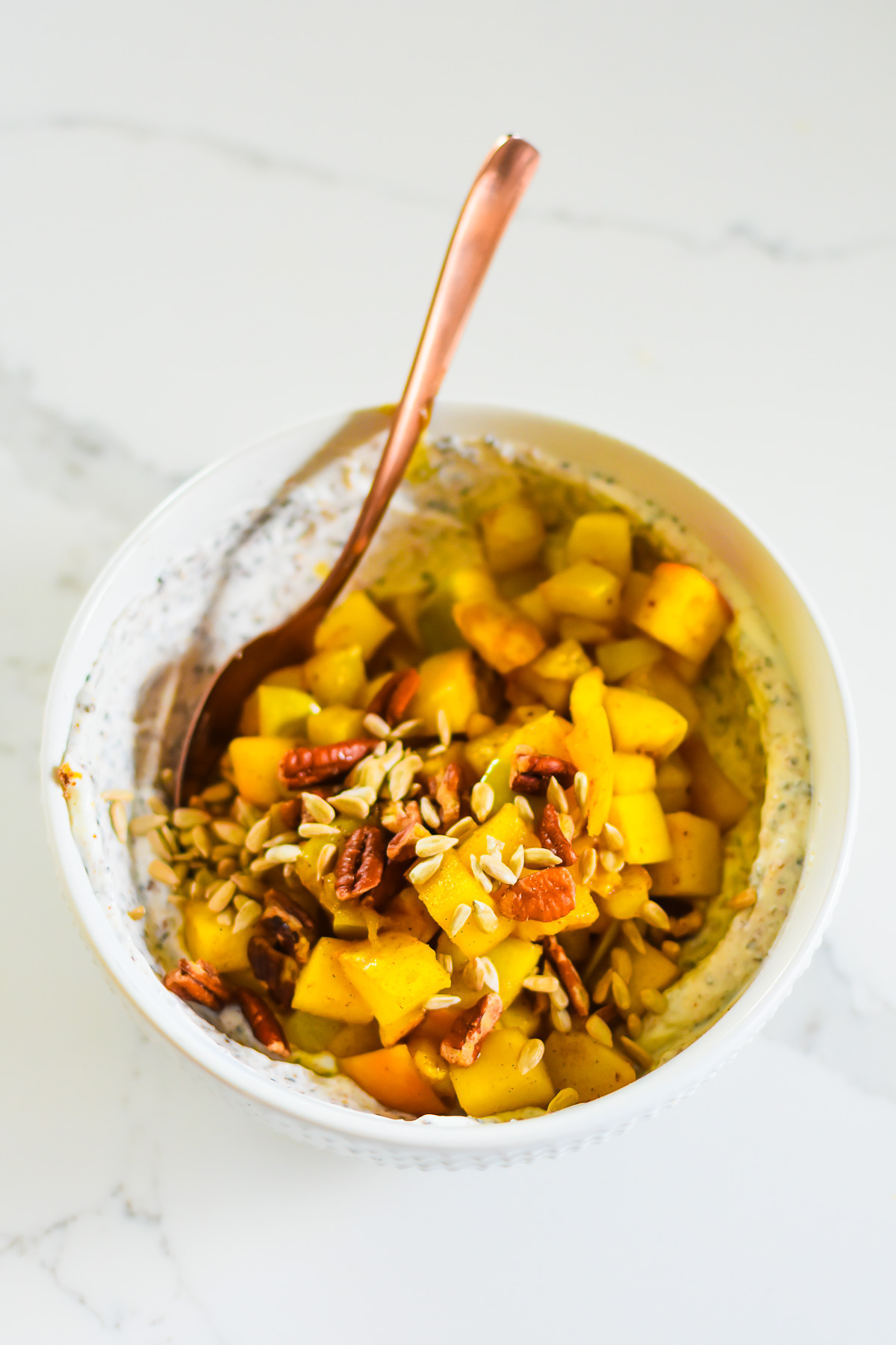 stewed apple yogurt bowl with sunflower seeds and pecans.