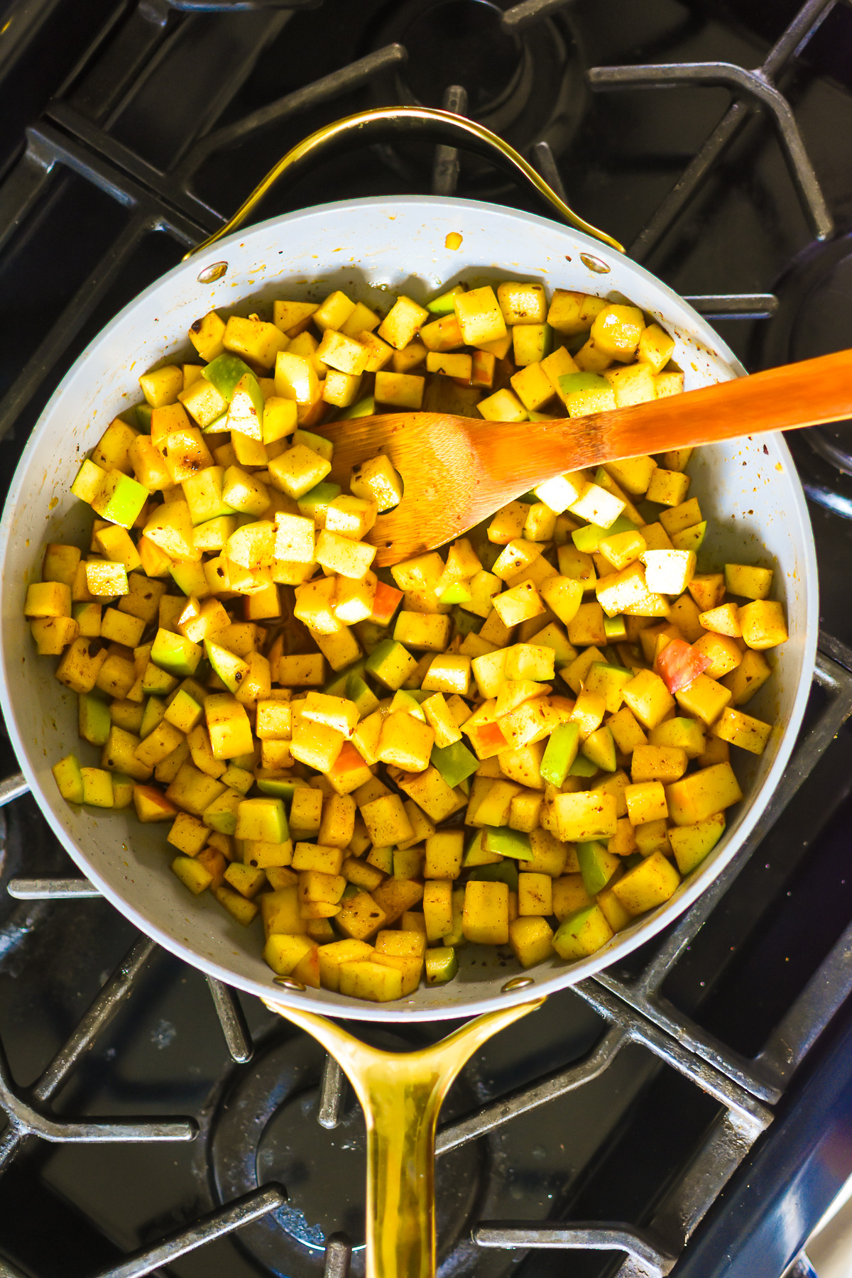 cooking apples in skillet on stove top with spices, vanilla, lemon, and honey.