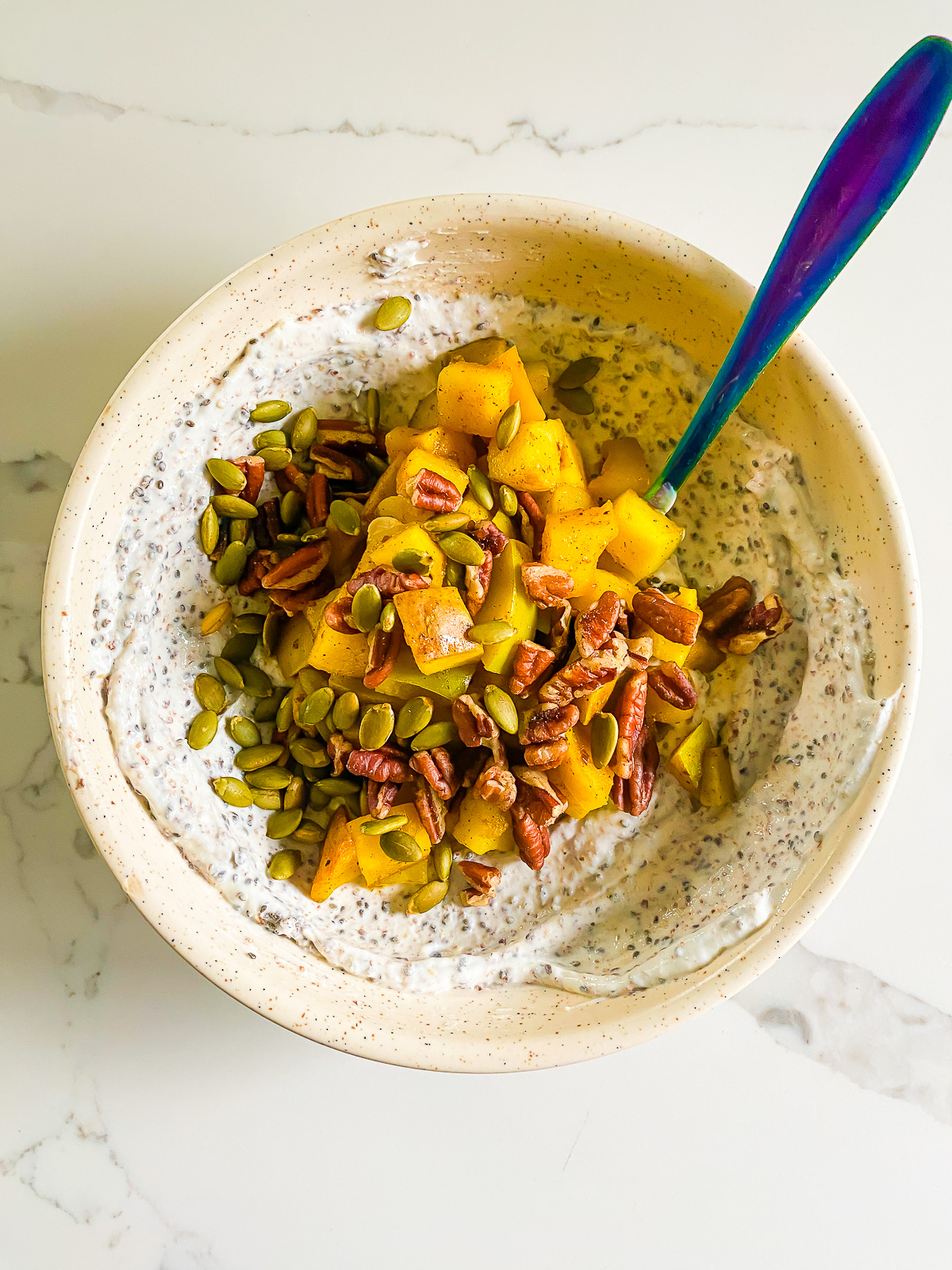 stewed bartlett pears with pecans and pepitas over Greek yogurt for a healthy breakfast bowl.