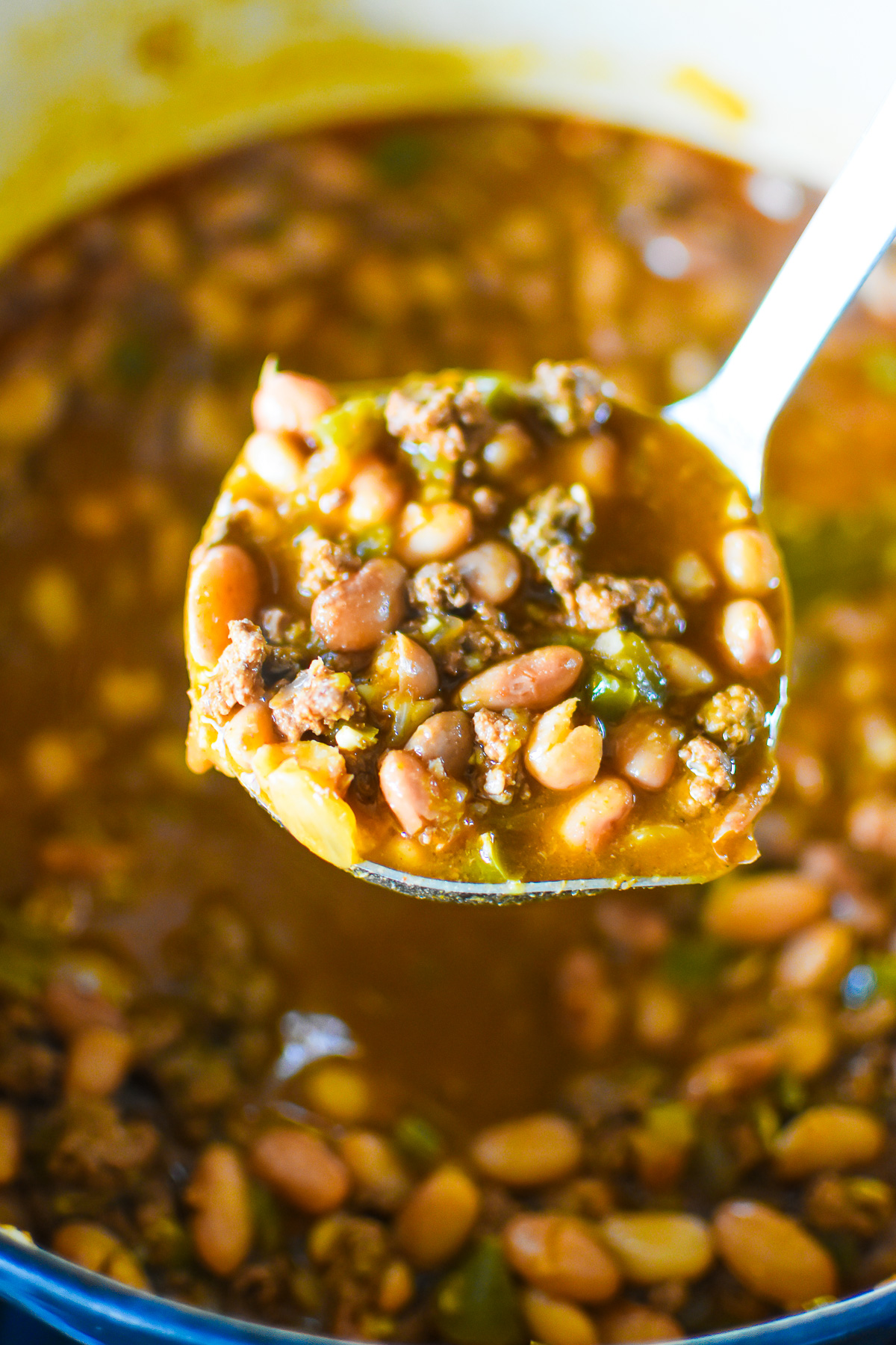 soup ladle full of chili beans with pinto beans and ground beef.