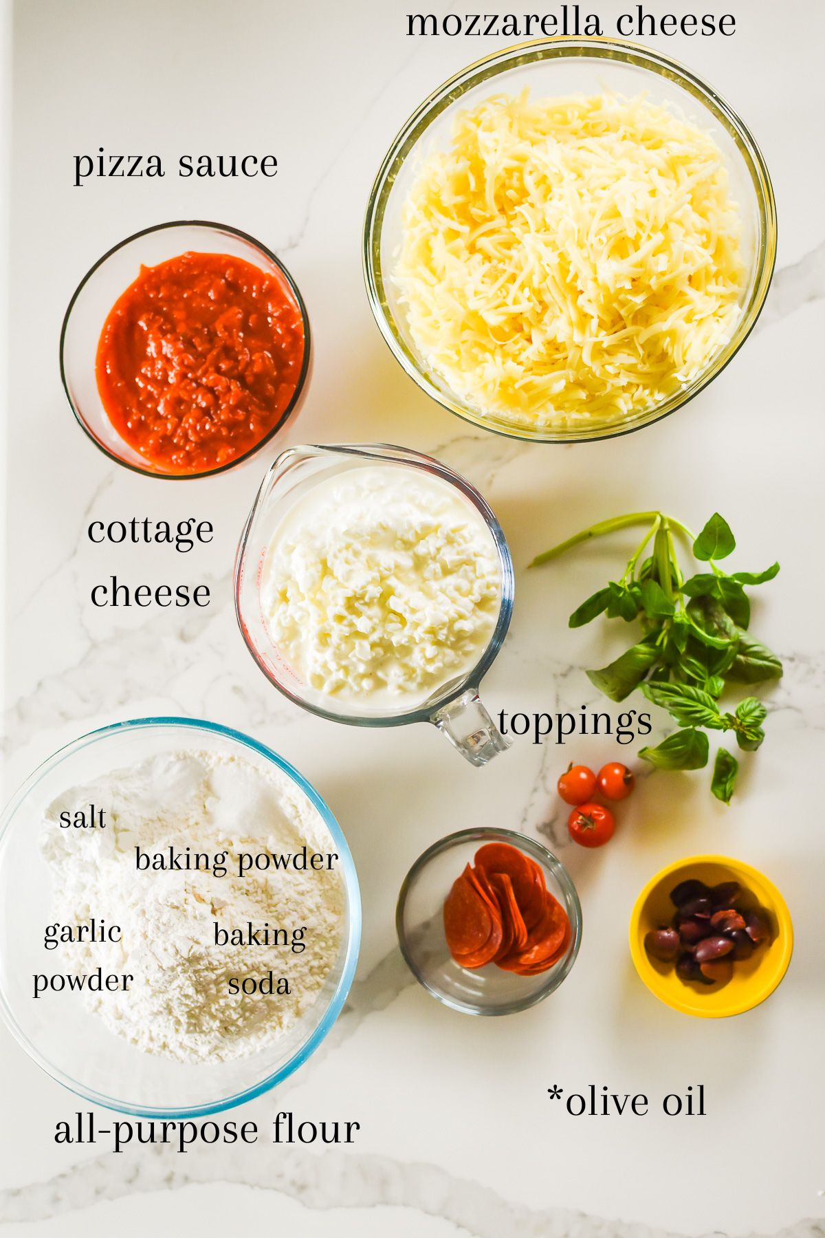 ingredients for XL sheet pan pizza on granite counter top: shredded mozzarella cheese, pizza sauce, cottage cheese, flour, salt, garlic powder, baking powder and soda, and assorted toppings.
