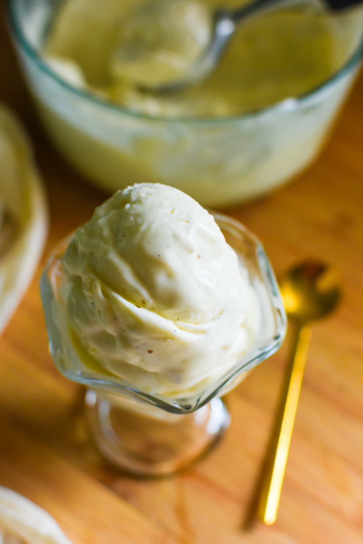 creamy scoop of the best vanilla bean ice cream from scratch in a glass dessert dish.
