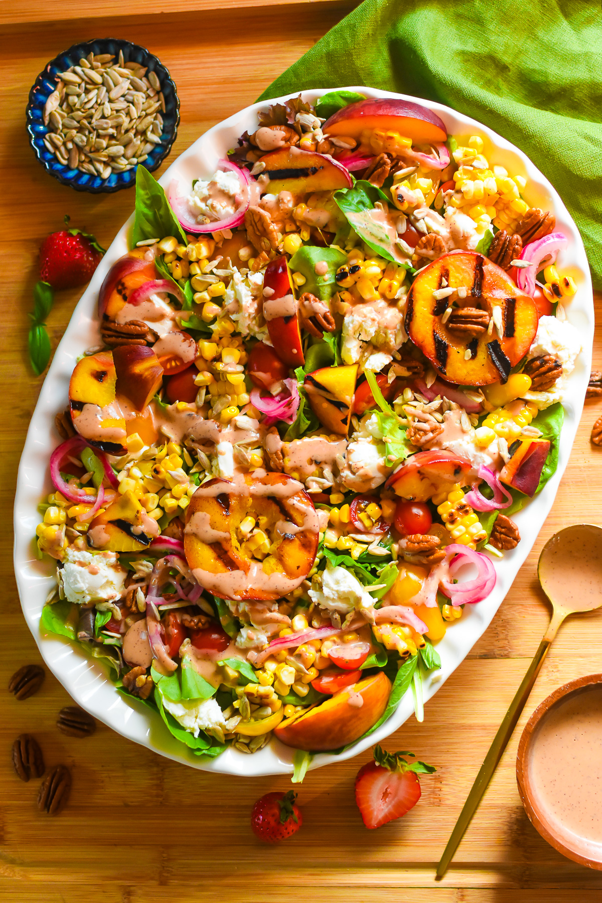 platter of a mixed greens and grilled peach salad with basil and strawberry vinaigrette.