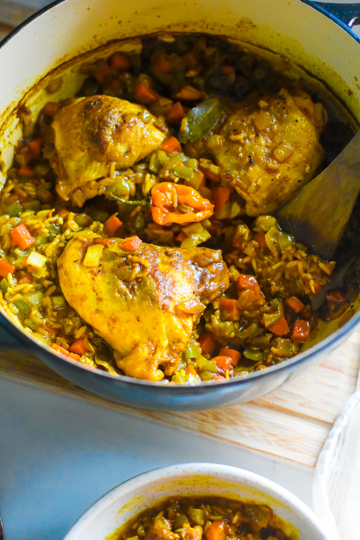 one pan baked curry chicken and rice with authentic Jamaican flavor in a black enameled Dutch oven.