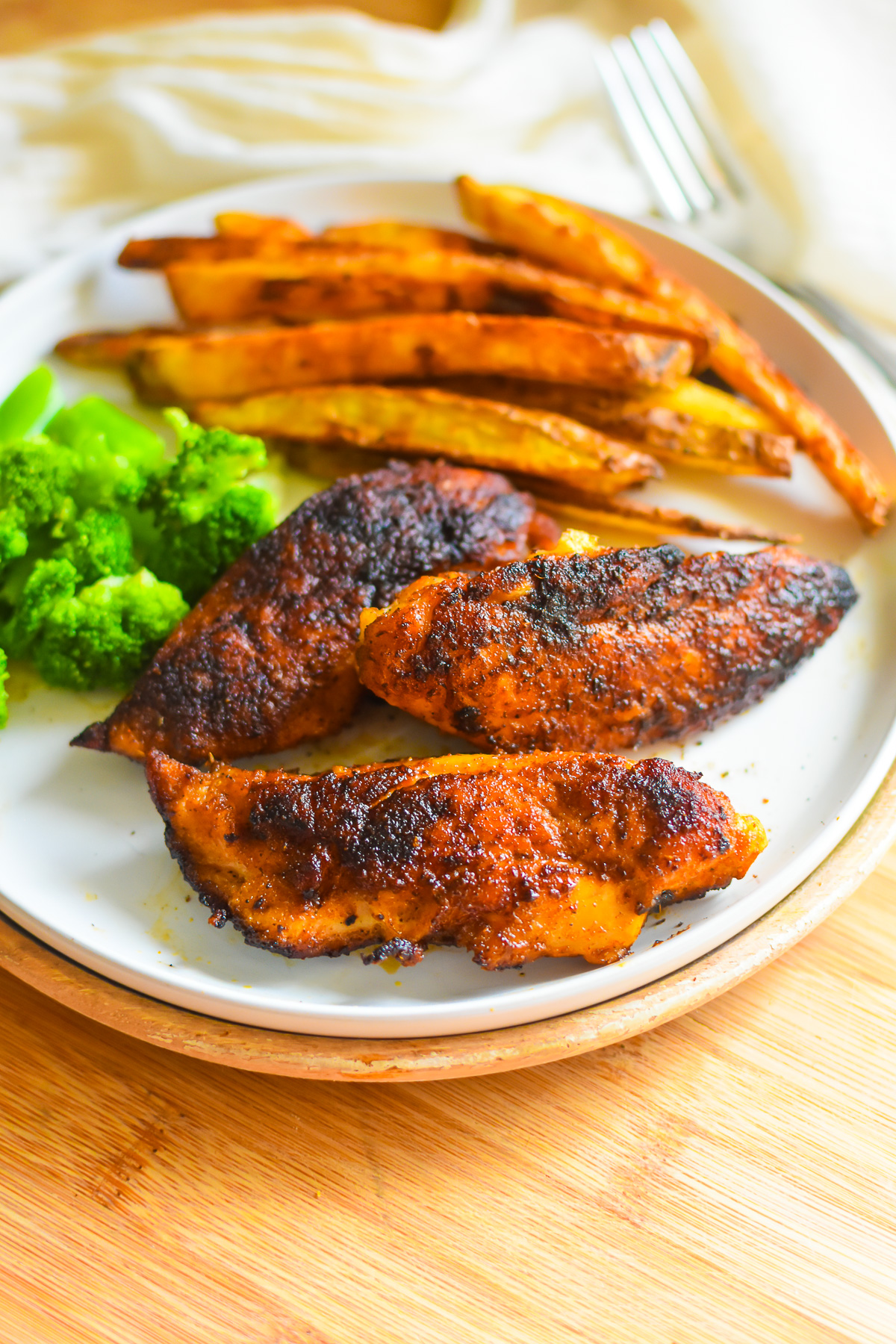 the best homemade blackened chicken tenders served with broccoli and oven fries.