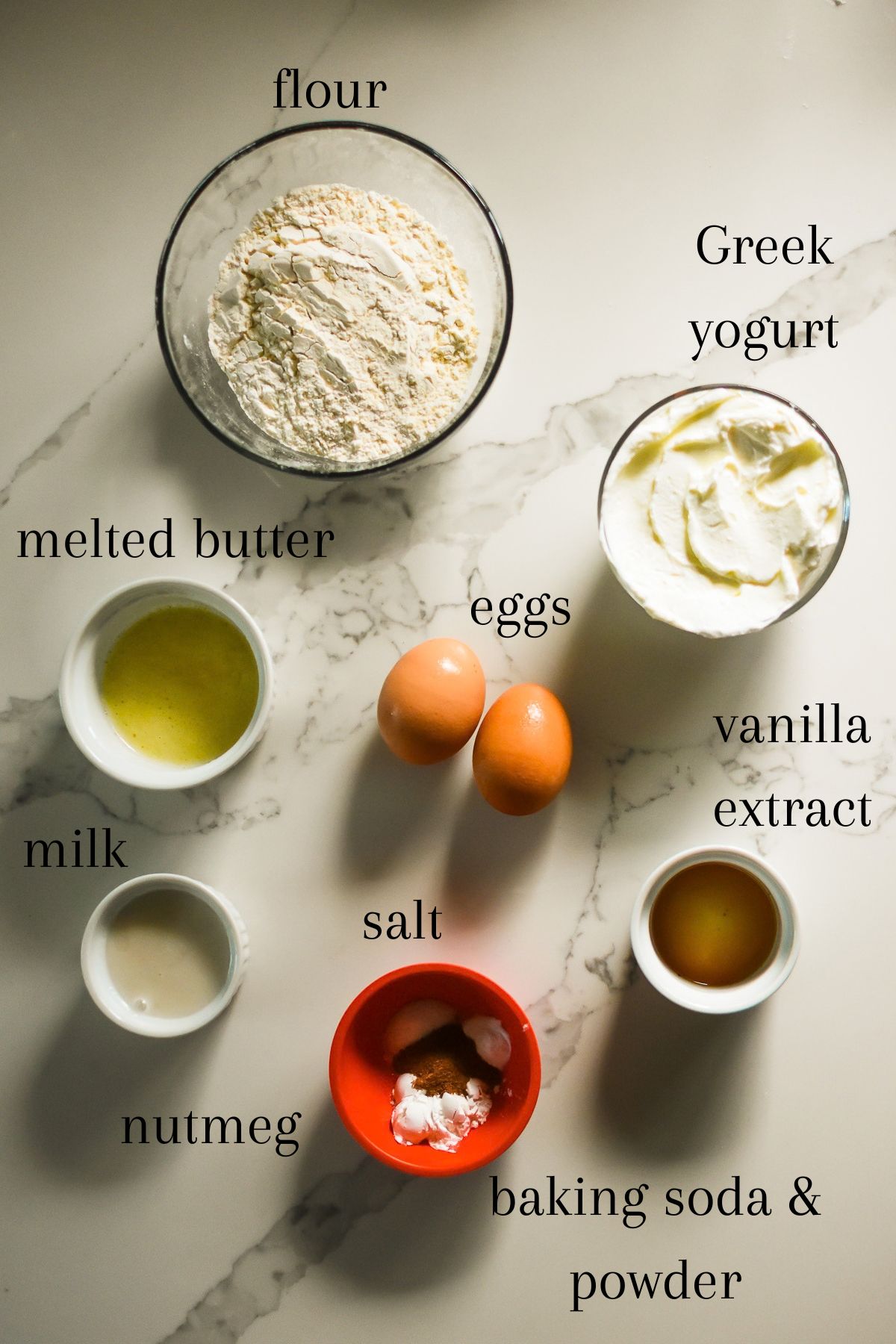 ingredients for making fluffy greek yogurt pancakes healthy: all-purpose flour, unflavored greek yogurt, melted butter, eggs, vanilla extract, milk, salt, nutmeg, baking soda, and baking powder.
