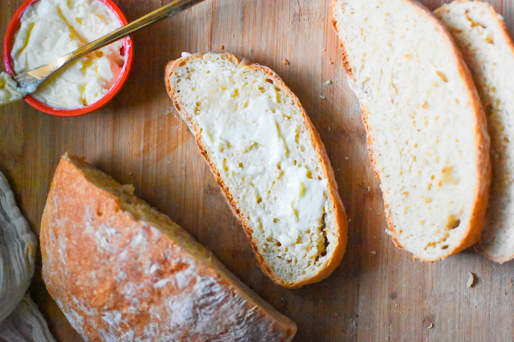 slices of easy old fashioned buttermilk bread on a wooden cutting board with softened butter.